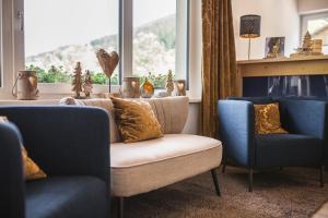 克雷纳尔波顿沃特酒店的客厅配有两把椅子、一张沙发和一个窗口