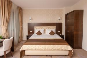 比斯特里察Grand Hotel Coroana的酒店客房设有一张大床和一张书桌。