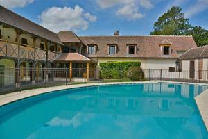 Aillant-sur-TholonDomaine Du Roncemay - Hôtel, Restaurants, Spa & Golf的一座带建筑物的房子前的游泳池