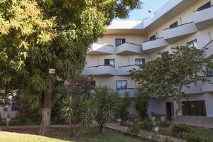 巴雷拉斯Solar das Mangueiras的公寓大楼前面有树木