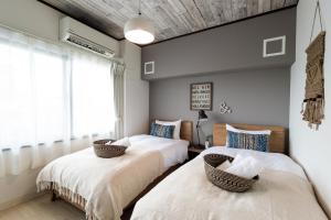 宜野湾市Little Santa的一间卧室设有两张床和窗户。