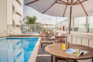 弗洛里亚诺波利斯弗洛里亚诺波利斯因特城市酒店的一个带桌椅和遮阳伞的游泳池