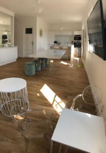 波克罗勒岛APPARTEMENT GRAND CONFORT PORQUEROLLES的一间厨房,内设白色的桌椅