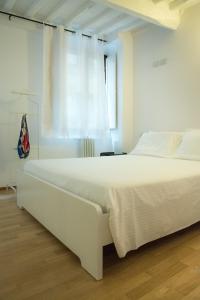 锡耶纳La casa in Camollia的白色卧室内的一张白色床,设有窗户
