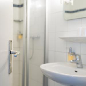 康斯坦茨博登湖兰德酒店的白色的浴室设有水槽和淋浴。