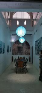 拉穆Jamala Guesthouse的一间带桌椅和吊灯的用餐室