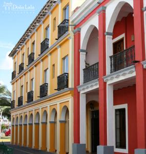 特拉科塔尔潘Hotel Posada Doña Lala的黄色和红色的建筑,在街上设有阳台