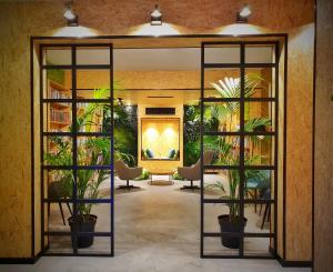 内尔哈MB Hostels Premium ECO - Adults Recommended的大堂里种有盆栽植物,墙上挂着一幅画