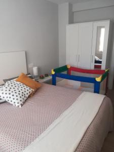 蒙达卡Apartamento tranquilo y luminoso的一间卧室配有一张床和一张色彩缤纷的椅子