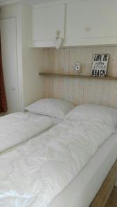 比伦Chalet Seazon O1的墙上有标牌的房间,配有两张白色的床