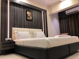 孟买Hotel Avon Ruby Dadar的一间卧室设有一张大床和大窗户