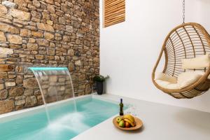 圣斯特凡诺斯Obsession Mykonos的浴缸里备有一碗水果和一瓶葡萄酒