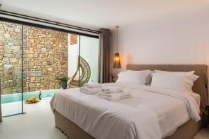 圣斯特凡诺斯Obsession Mykonos的一间卧室配有一张大床和毛巾