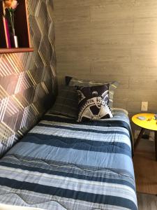 贝洛奥里藏特Bilingual Home的一间卧室配有一张带蓝色毯子和一张桌子的床。