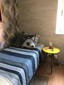 贝洛奥里藏特Bilingual Home的一间卧室配有一张床和一张黄色的桌子