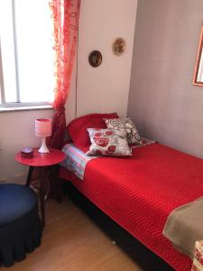 贝洛奥里藏特Bilingual Home的一间小卧室,配有红色的床铺和红色的毯子