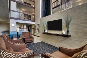 休斯顿Sonesta Essential Houston Hobby Airport的酒店大堂设有椅子和平面电视。