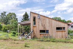 ZempowStudio Zempow, ökologisches Ferienhaus的田野上的木房子,带栅栏
