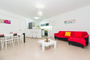 夫塞塔Apartamento Praia Fuzeta的客厅配有红色的沙发和桌子