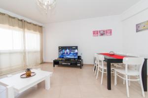 夫塞塔Apartamento Praia Fuzeta的客厅配有桌子和电视