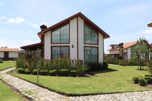 塔帕尔帕Cabañas Molino del Rey的草坪上带玻璃窗的房子