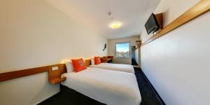 悉尼悉尼机场宜必思快捷酒店的一间酒店客房,设有两张床和电视