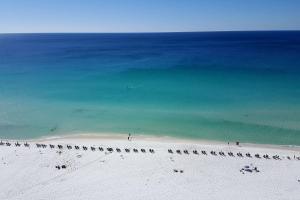 德斯坦Pelican Beach Resort Rentals的海滩上带一组椅子的海滩