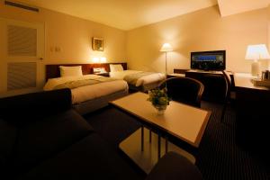 青森青森酒店的酒店客房,设有两张床和一张沙发