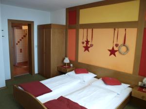 LederwinkelSportgasthof Lipp的一间卧室配有两张带红色枕头的床