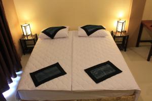 沙湾拿吉阿瓦隆公寓的一张配有白色床单和枕头的大床