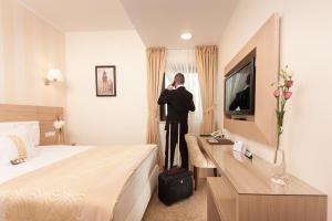 比斯特里察Grand Hotel Coroana的一个人站在酒店房间