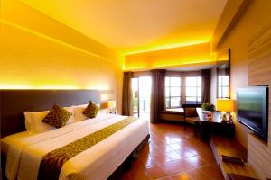 波德申Thistle Port Dickson Resort的酒店客房设有一张大床和一台电视。