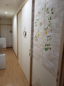 长崎GardenRoom bnb Yumyum的砖墙上一棵树的壁画