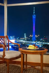 广州广州凯旋华美达大酒店的一张桌子,上面放着一盘水果,享有塔楼的景色