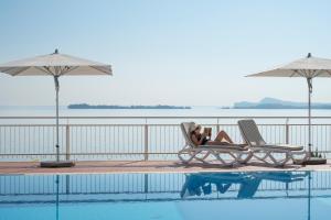 加尔多内-里维耶拉佛罗里达别墅酒店套房&套房公寓的一位躺在游泳池旁椅子上的女人