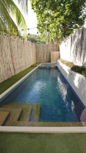 科隆Treetop Suites的后院的游泳池,带有木栅栏