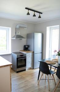 凯尔德拉Modern apartment in the heart of Kärdla的厨房配有桌子和不锈钢冰箱。