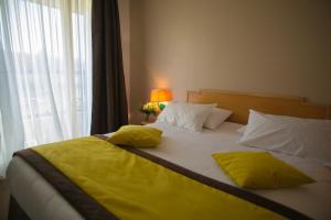 吕扎什格尔福蒙格力风酒店的一张带黄色床单和枕头的床,靠窗