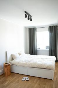 凯尔德拉Modern apartment in the heart of Kärdla的卧室配有白色的床和窗户。