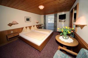 湖滨福煦萨尔茨堡霍夫旅馆的一间卧室配有一张床和一张花瓶桌子