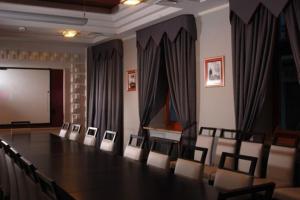 弗沃茨瓦韦克维多利亚酒店的一间会议室,配有桌椅和屏幕
