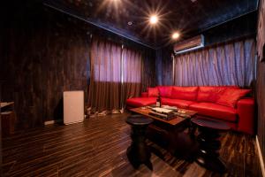 东京K&K Jujo House的客厅配有红色的沙发和桌子