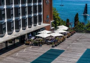 韦尔苏瓦Lake Geneva Hotel的建筑物旁边一排带白色遮阳伞的桌子