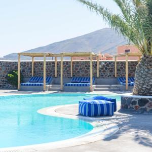 伊亚安尼摩米里洛斯酒店的一个带蓝色椅子和棕榈树的游泳池