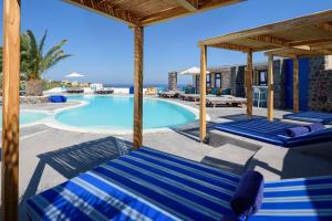 伊亚安尼摩米里洛斯酒店的一个带蓝色躺椅的游泳池,一个度假胜地
