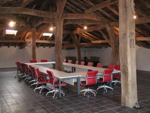 Odériz艾特萨托乡村民宿的一间会议室,配有长桌子和红色椅子