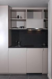 雅典Azur Suites的厨房配有白色橱柜和水槽