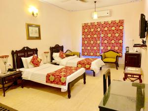 斋浦尔Suryaa Villa Jaipur - A Boutique Heritage Haveli的酒店客房设有两张床和窗户。