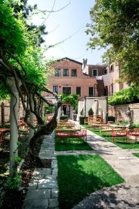 威尼斯Excess Venice Boutique Hotel & Private Spa - Adults Only的一座带桌椅的花园以及一座建筑