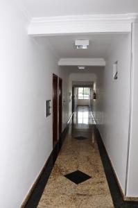 戈亚尼亚Hotel Buriti Shop的走廊设有白色墙壁和瓷砖地板